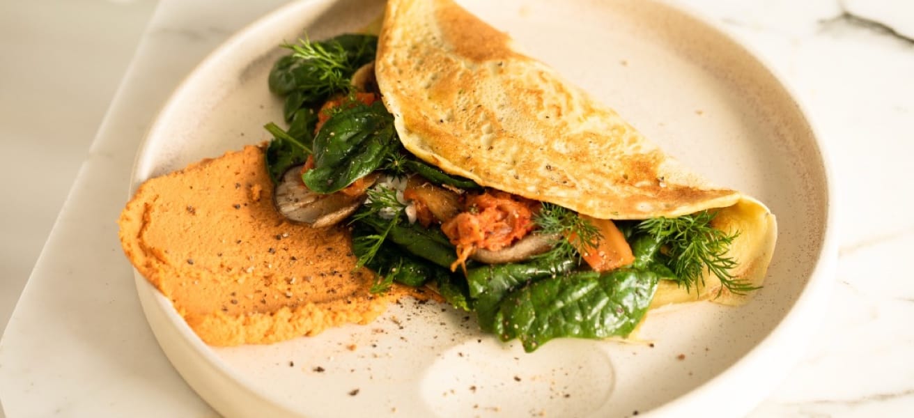A simple omelette garnished with fresh herbs and served on a plate.